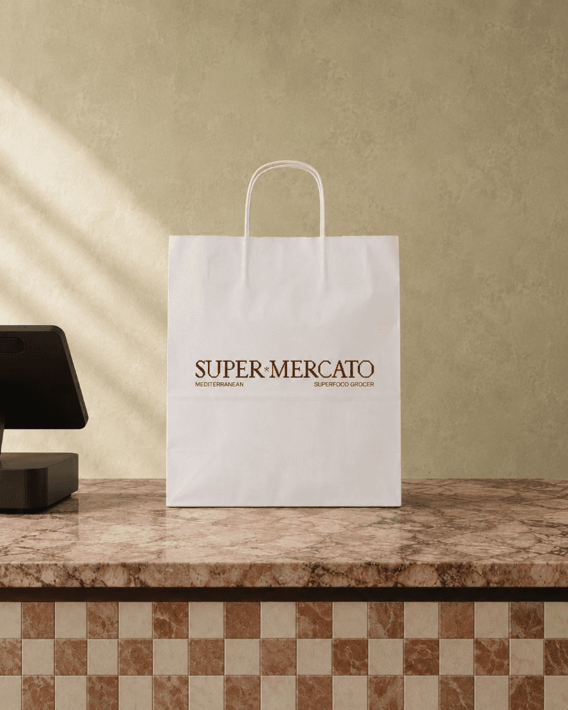 A Super Mercato paper bag packed and waiting on the counter