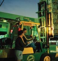 Michael Simonetta at the markets, with a forklift lifting stacked lettuce boxes.